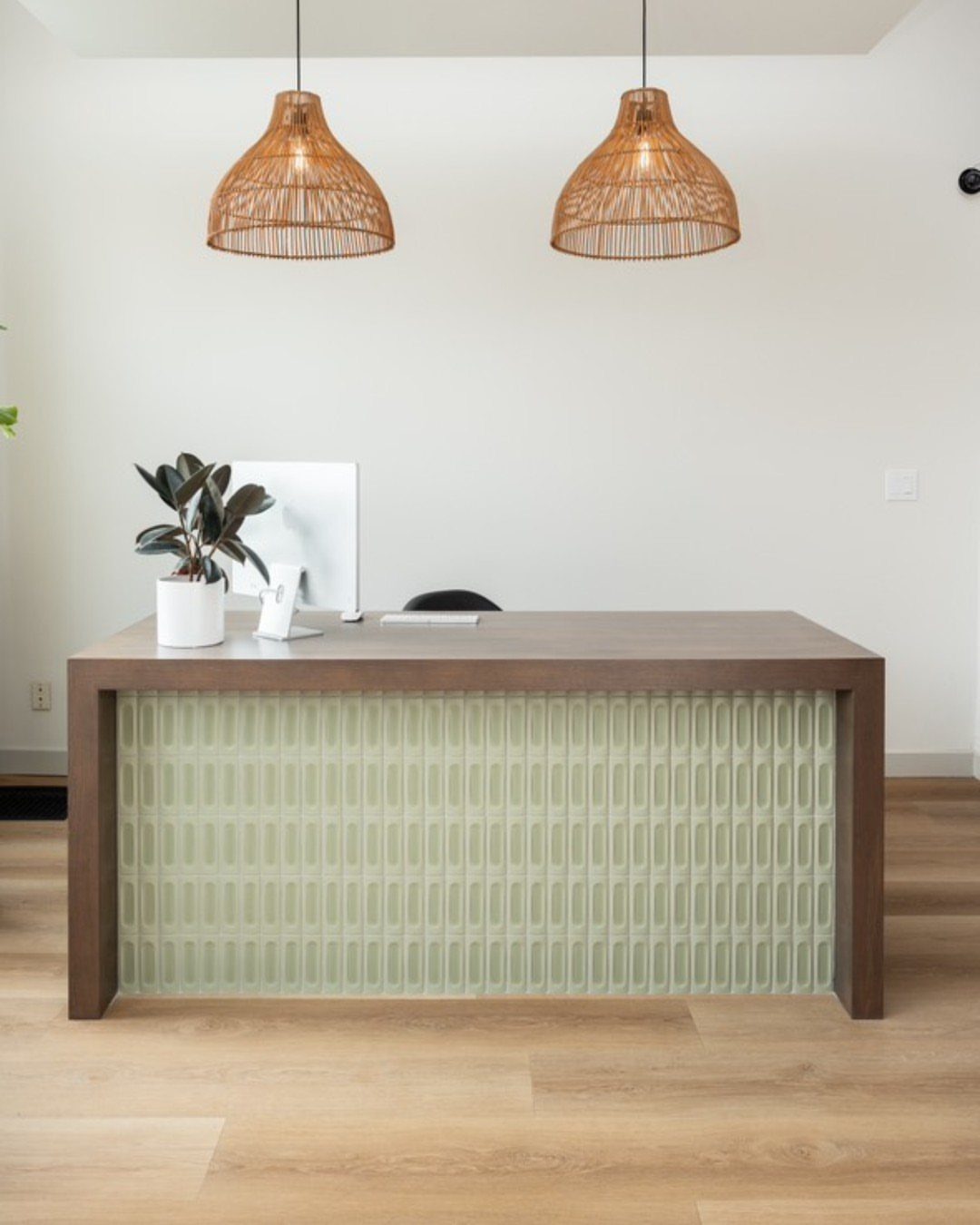 20 mil LVP Flooring: 6 Install Ideas for Home & Commercial Spaces 6 Light wood luxury vinyl plank flooring under a modern reception desk with wicker pendant lights.