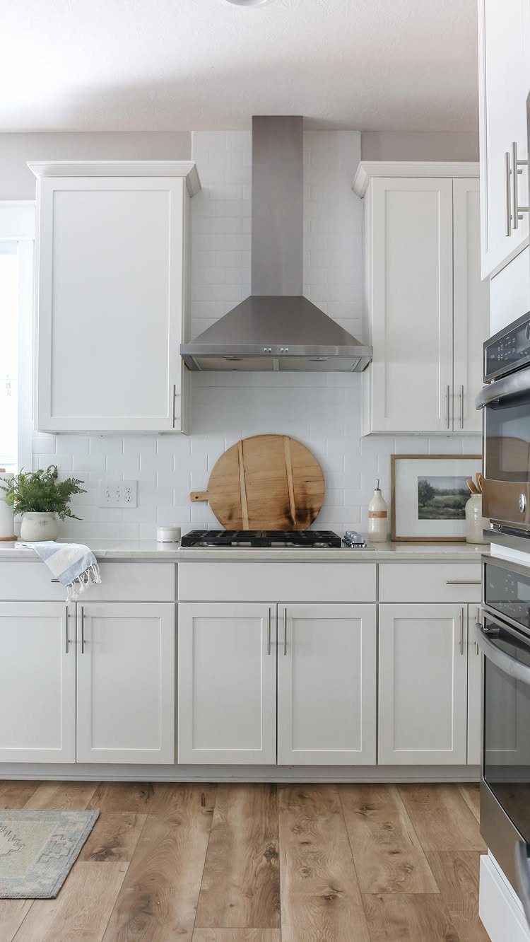 20 mil LVP Flooring: 6 Install Ideas for Home & Commercial Spaces 2 Light wood-look luxury vinyl plank flooring installed in a bright, modern white kitchen.