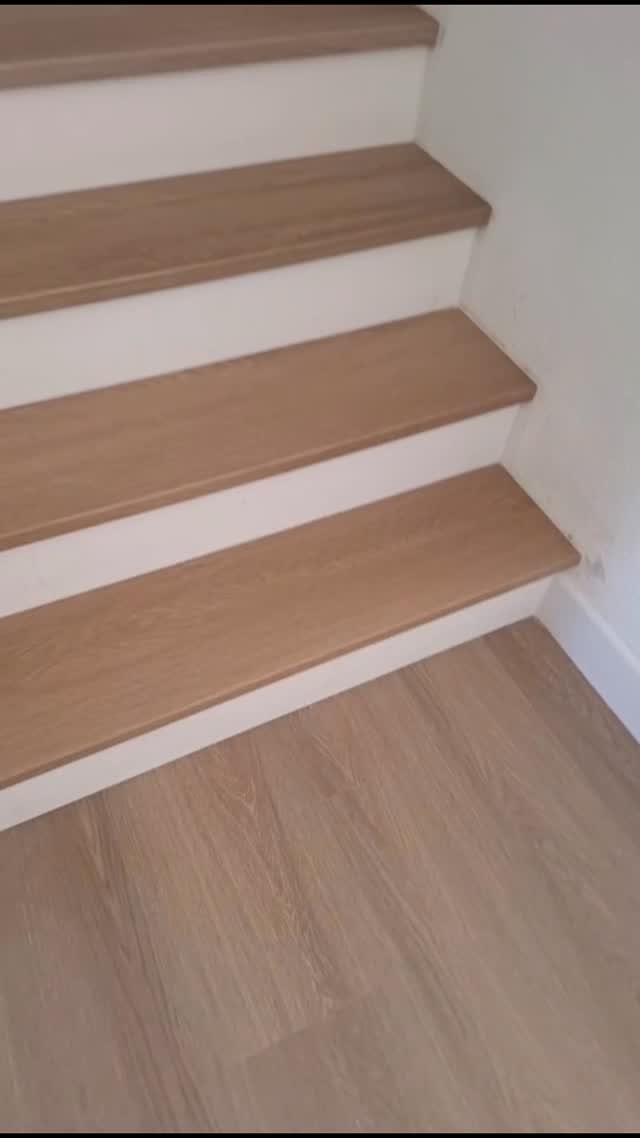 20 mil LVP Flooring: 6 Install Ideas for Home & Commercial Spaces 4 Light wood-toned vinyl plank flooring installed on staircase steps and the bottom floor landing.