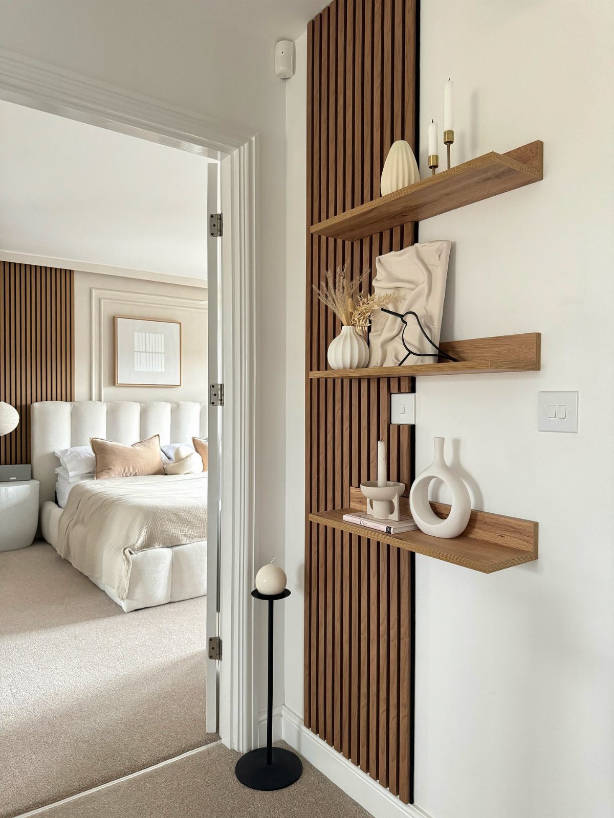 10 Accent Wall Panels for Every Room Style 7 Vertical wooden slat accent wall panels with floating wooden shelves holding white decorative vases.