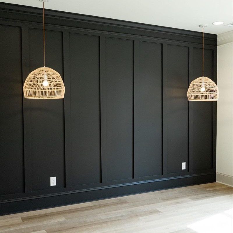 10 Accent Wall Panels for Every Room Style 5 Black vertical wall panels with decorative molding and two woven pendant lights hanging in a room.