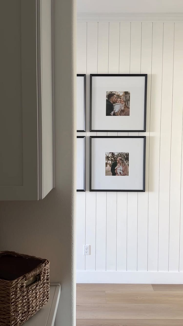 10 Accent Wall Panels for Every Room Style 1 White vertical shiplap wall panels with two black framed photos hanging on them.
