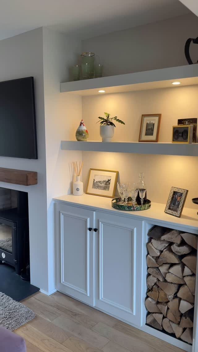 17 Built-In Shelves Living Room Ideas That Balance Style and Storage 3 White built-in shelves with integrated lighting and decorative items next to a fireplace.