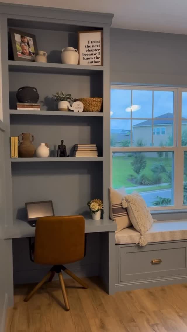 17 Built-In Shelves Living Room Ideas That Balance Style and Storage 14 Blue built-in shelving unit with an integrated desk and a cushioned window seat by a window.
