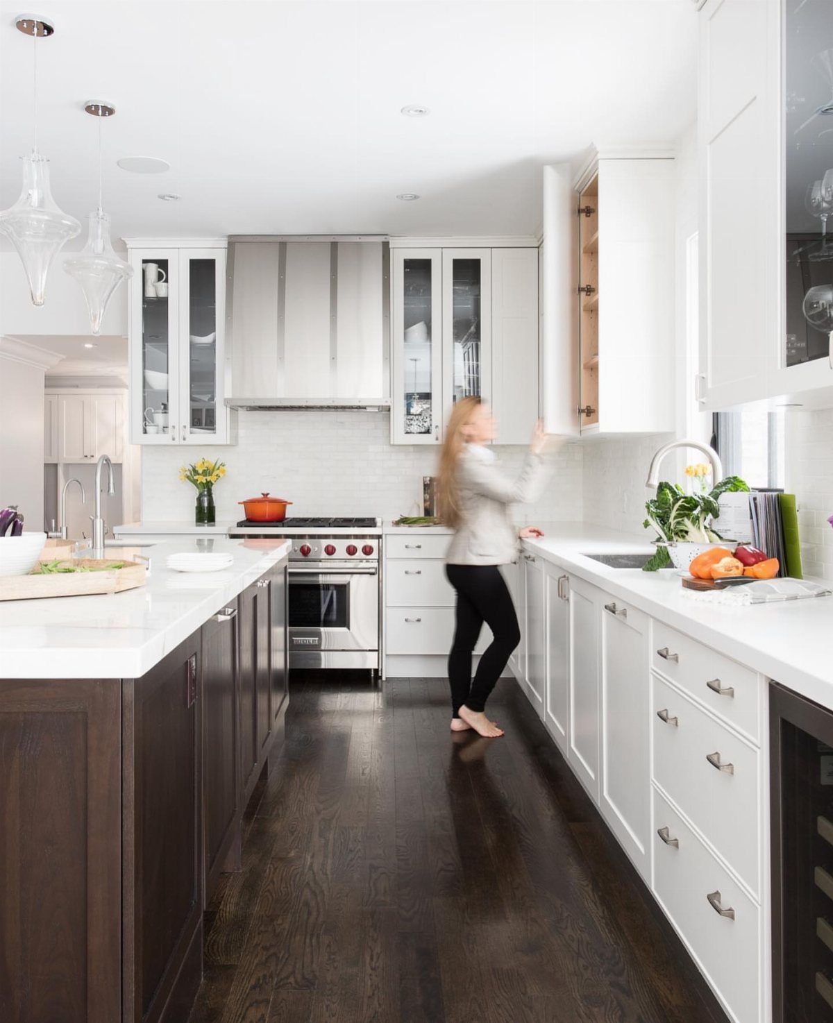 Dark Wood Floors with Light Wood Cabinets: 10 Kitchen Pairings 1 White kitchen cabinets and countertops paired with dark hardwood flooring.