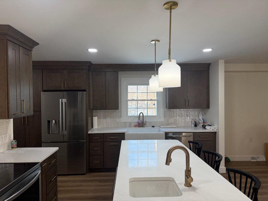 Dark Wood Floors with Light Wood Cabinets: 10 Kitchen Pairings 9 Dark mocha wooden cabinets paired with white countertops and dark wood floors in a modern kitchen.