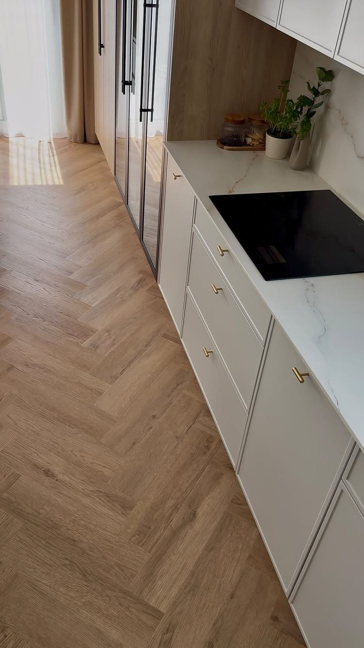 Fancy Wood Floors: 8 Ideas for Rich, Character-Filled Spaces 3 Light wood flooring with a herringbone pattern in a modern white kitchen.