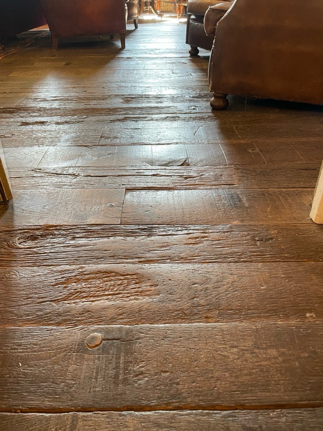 Fancy Wood Floors: 8 Ideas for Rich, Character-Filled Spaces 1 Weathered dark wood planks with deep textures and visible grain in a rustic room setting.