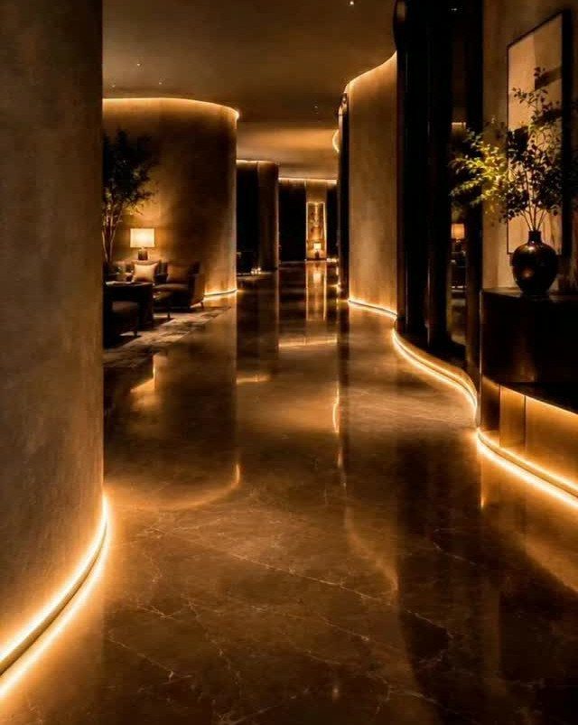 Floor and Wall Color Combinations: 27 Rooms That Get It Right 26 Polished dark marble floor reflecting warm LED light strips along curved beige walls in a hallway.