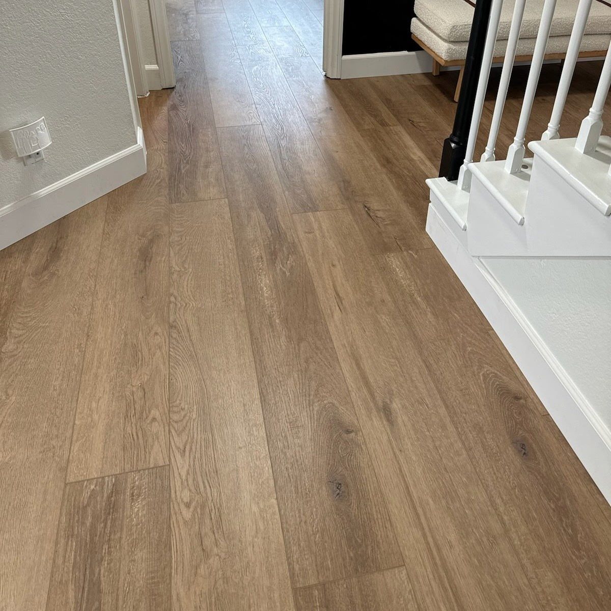 Floor and Wall Color Combinations: 27 Rooms That Get It Right 27 Light brown wood-textured flooring meeting a white wall and staircase in a bright hallway.