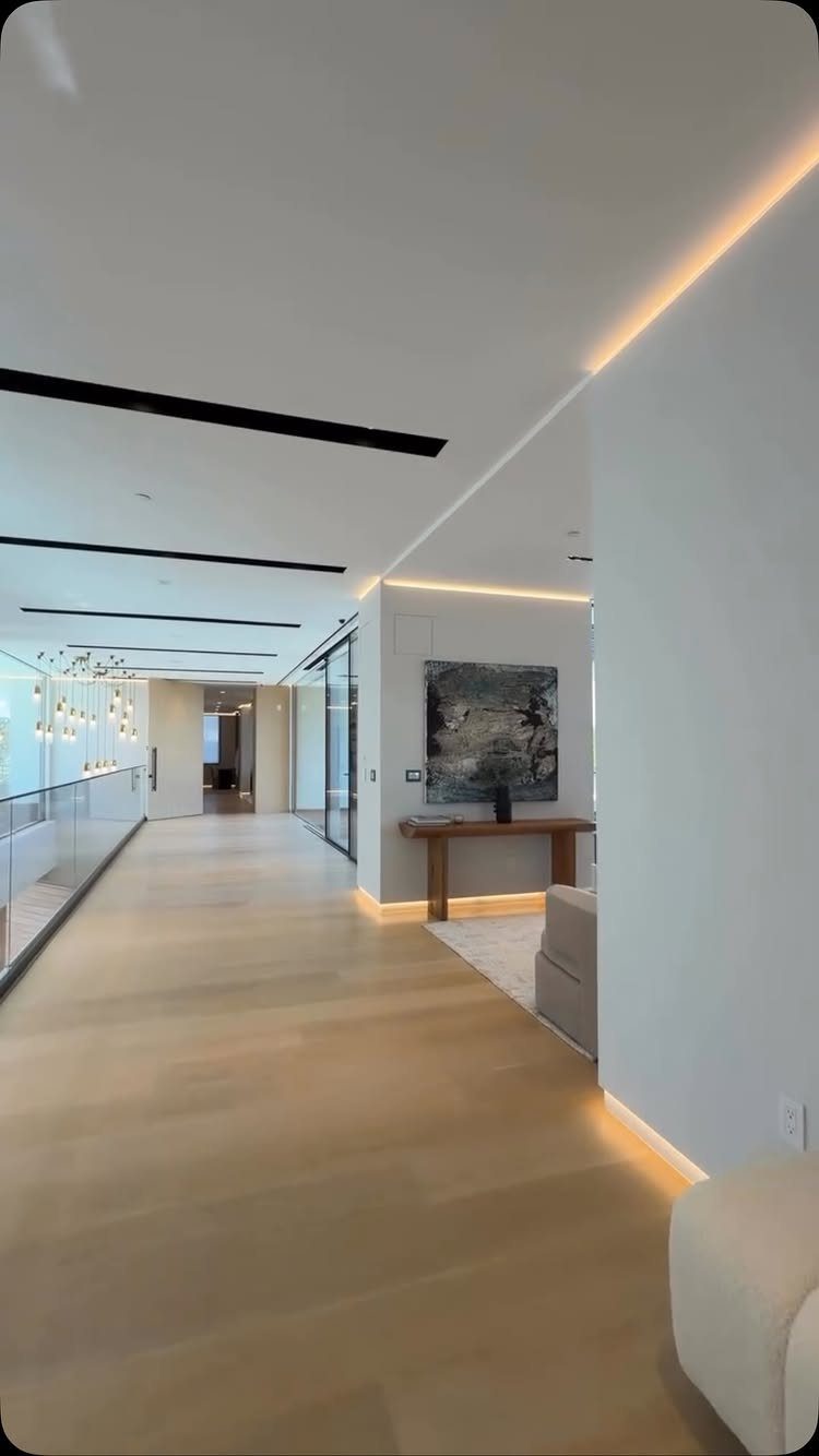 Floor and Wall Color Combinations: 27 Rooms That Get It Right 2 Light hardwood floors and white walls in a modern, brightly lit interior hallway.