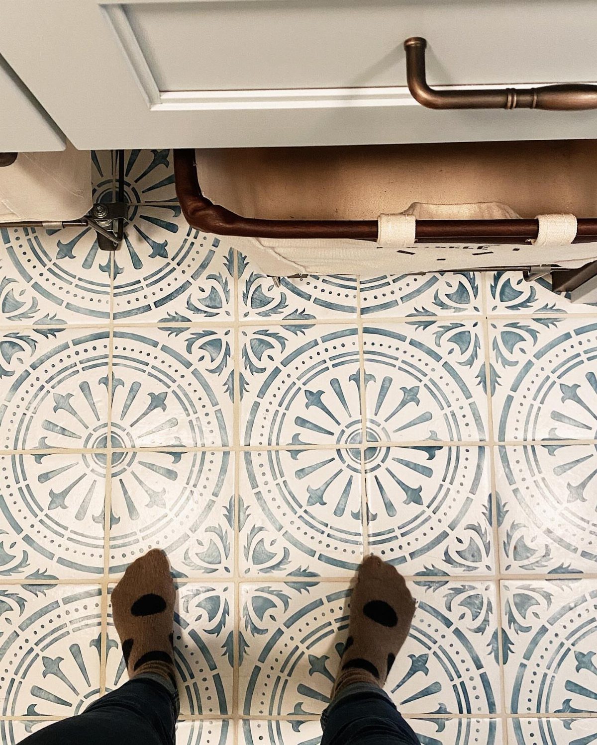 Floor Tile for Laundry Room: 11 Styles That Hold Up to Real Life 6 Blue and white patterned floor tiles viewed from above with a person's feet standing on them.