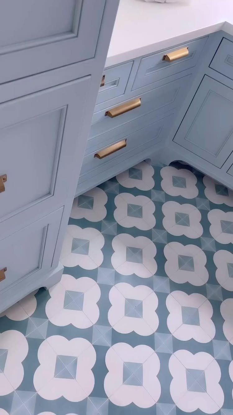 Floor Tile for Laundry Room: 11 Styles That Hold Up to Real Life 2 Blue and white patterned geometric tiles installed on a floor beneath light blue cabinets.