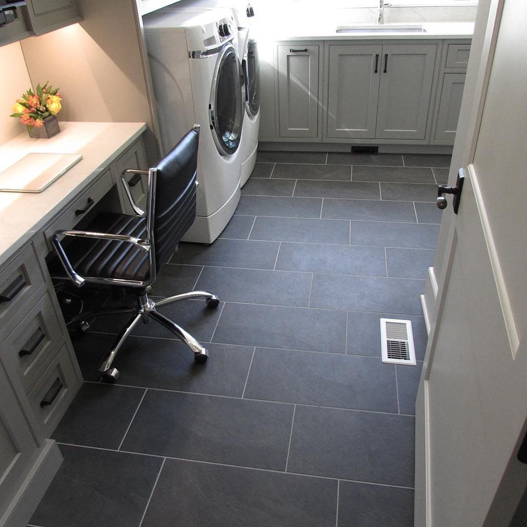 Floor Tile for Laundry Room: 11 Styles That Hold Up to Real Life 5 Dark gray rectangular floor tiles in a modern laundry room with gray cabinets and appliances.