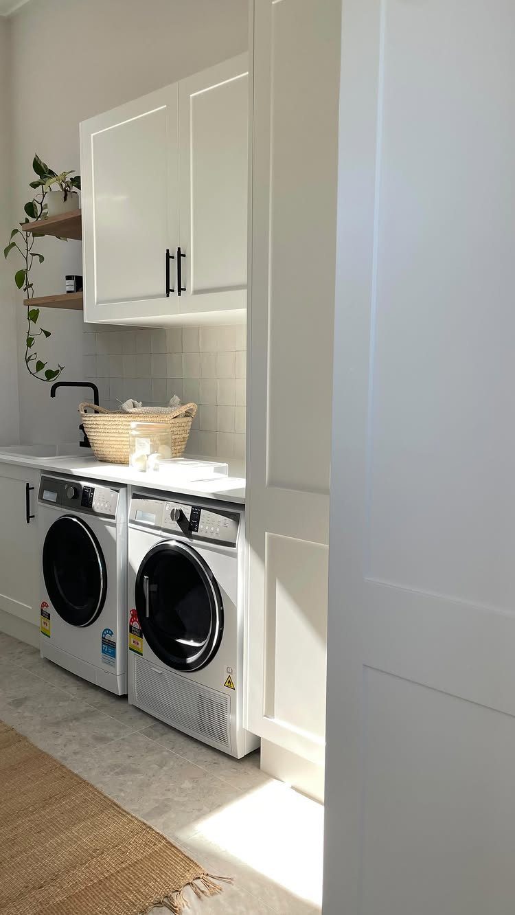 Floor Tile for Laundry Room: 11 Styles That Hold Up to Real Life 10 White laundry room with washing machines, cabinets, and light-colored floor tiles.