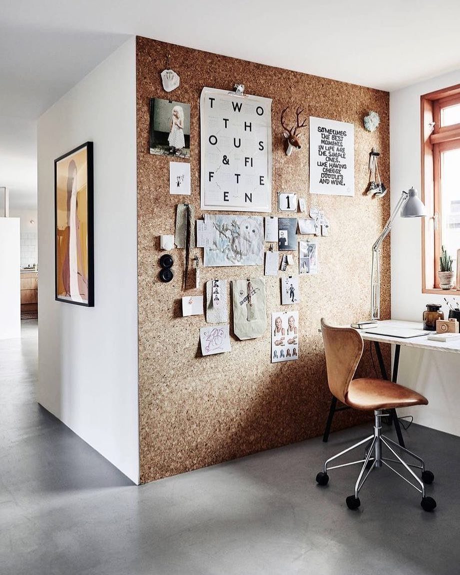 10 Interior Walls Ideas for 2026: Colors, Textures & Clever Details 6 A textured corkboard wall decorated with many photos, drawings, and notes in a bright room.