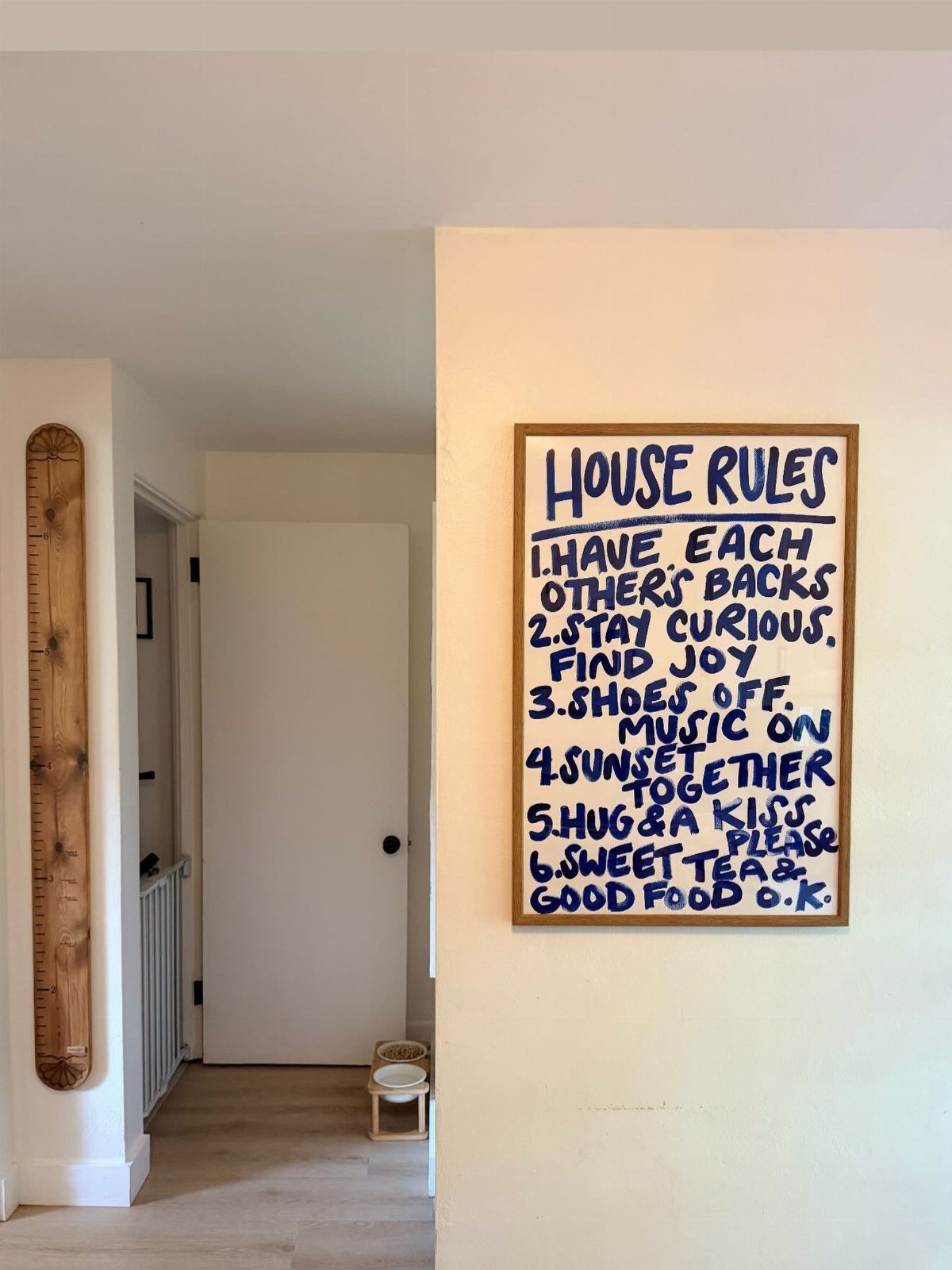 10 Interior Walls Ideas for 2026: Colors, Textures & Clever Details 10 A framed sign with handwritten blue house rules hangs on a cream interior wall.
