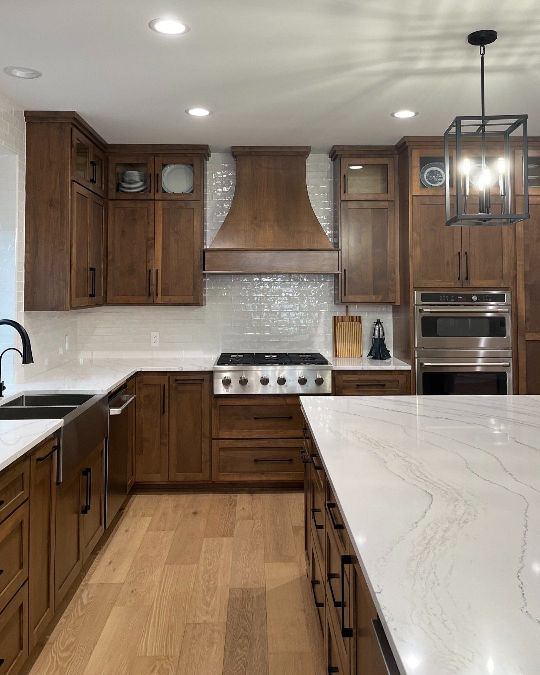 Kitchen Floors with Wood Cabinets: 10 Ideas That Work 7 Medium wood kitchen cabinets and a matching range hood paired with light wood plank flooring.