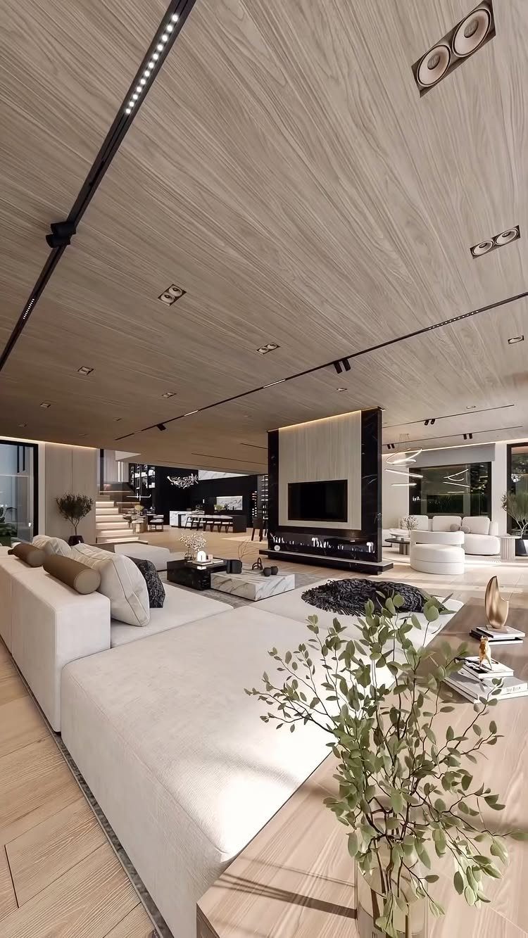 Modern living room with a white sectional sofa and a television mounted above a black fireplace.