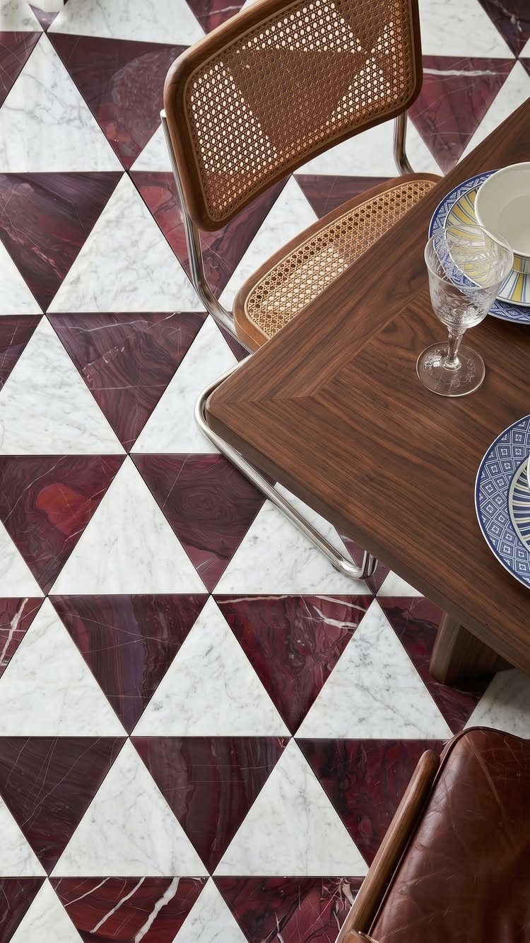 Geometric marble floor with white and dark red triangular patterns under a wooden dining table.