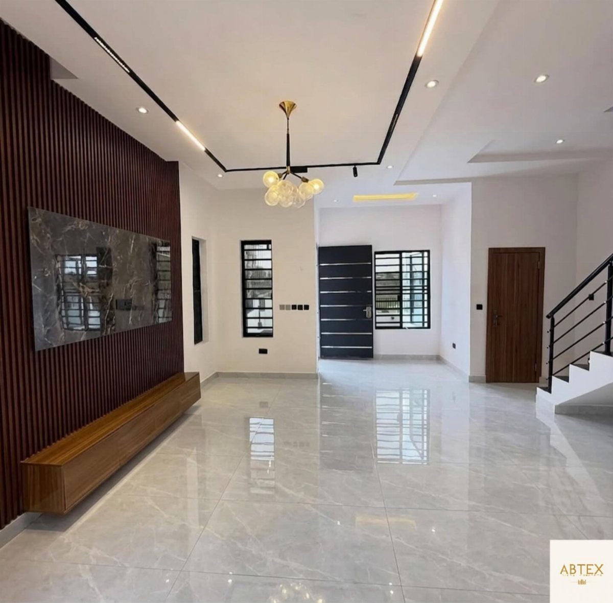 Polished white marble floor tiles in a modern, spacious living room with white walls.