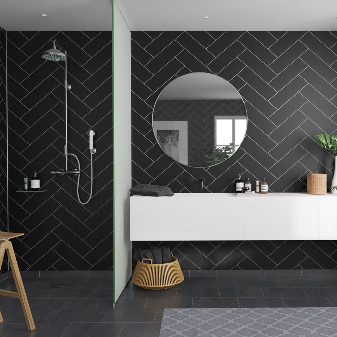 Modern bathroom with dark grey herringbone patterned wall panels and a white floating vanity.