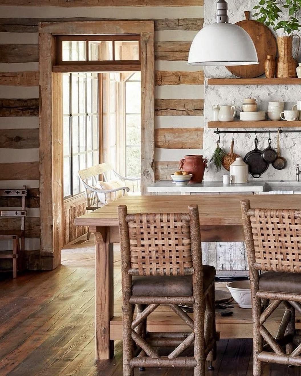 29 Rustic Farmhouse Kitchen Ideas That Feel Collected, Not Cataloged 19 Wooden dining table with woven branch chairs in a rustic kitchen with plank walls.