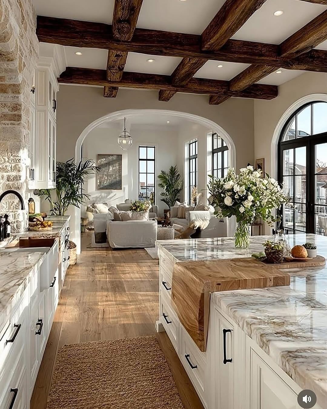 29 Rustic Farmhouse Kitchen Ideas That Feel Collected, Not Cataloged 18 White painted kitchen cabinets with marble countertops and dark wood ceiling beams.
