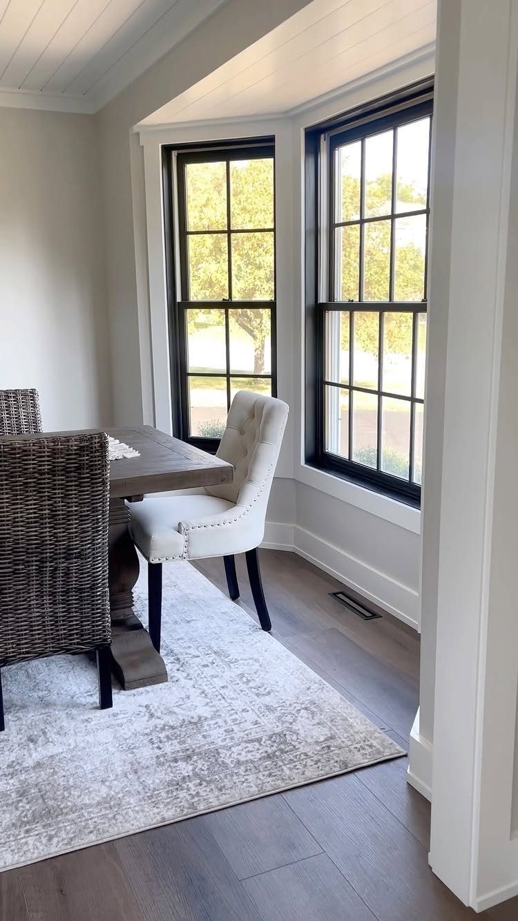 White baseboard moulding runs along the bottom of a light grey wall in a dining room.