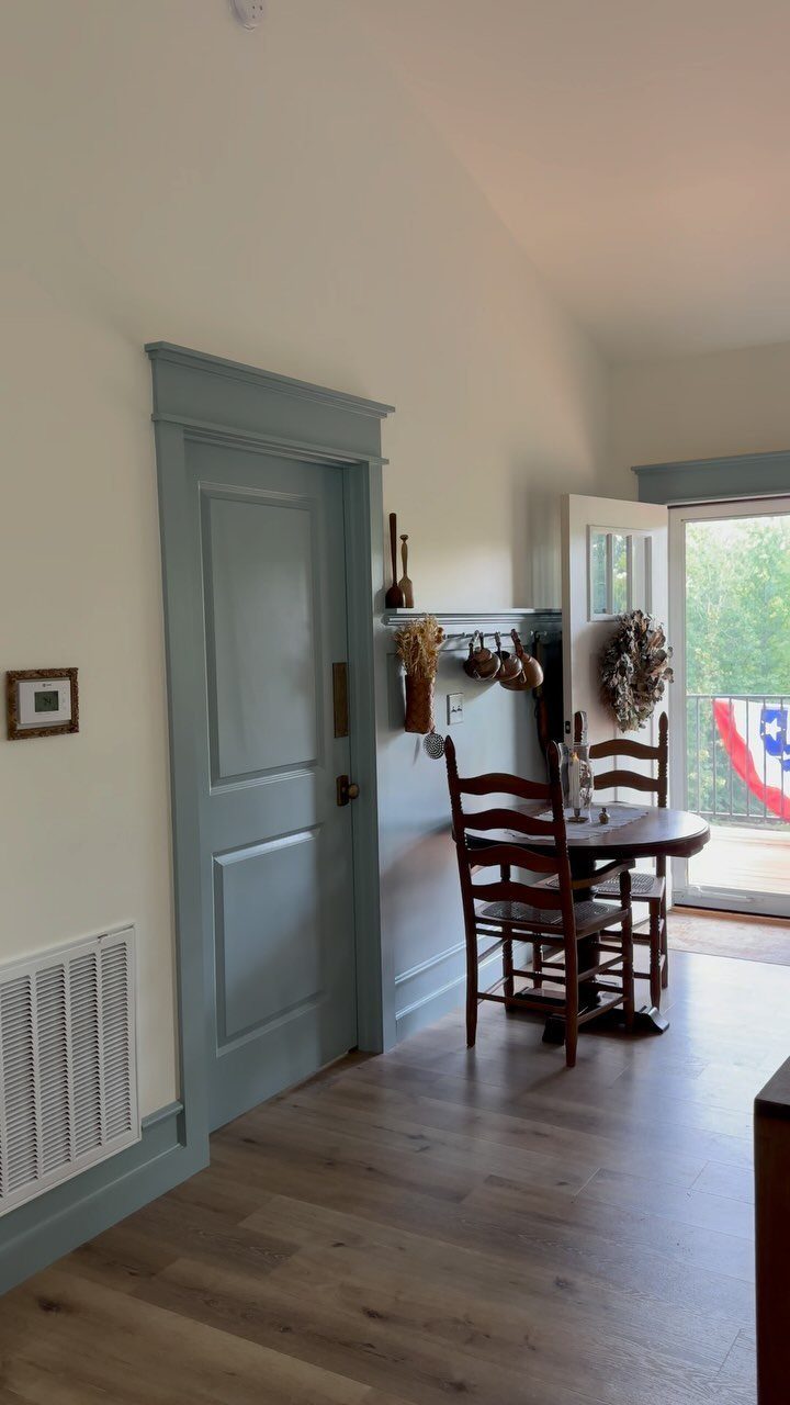 Trim Work on Walls: 8 Styles That Add Detail to Any Room 4 Light blue painted door and trim set against cream walls in a dining room.