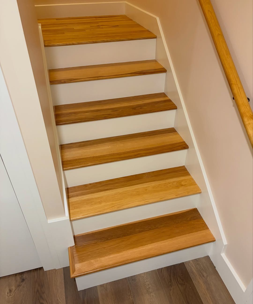 Trim Work on Walls: 8 Styles That Add Detail to Any Room 6 Wooden staircase with white risers and white baseboard trim along the walls.