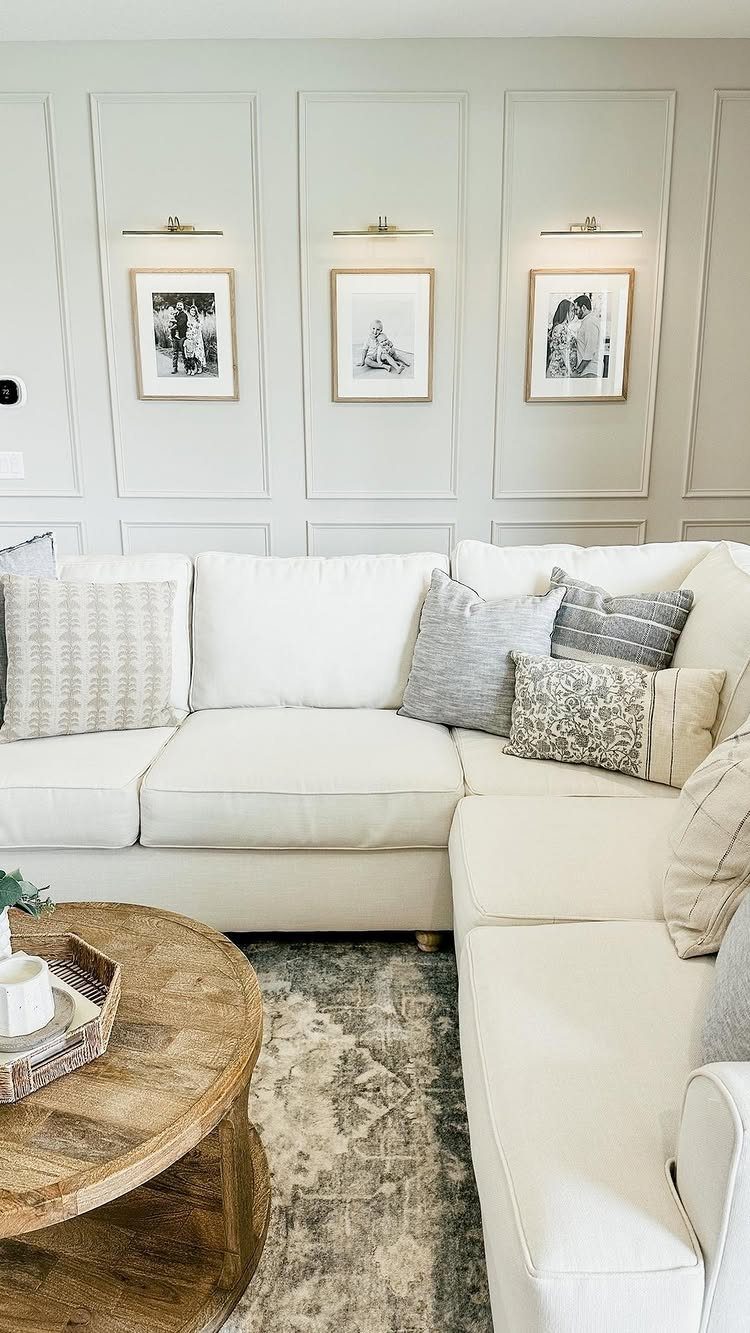 Trim Work on Walls: 8 Styles That Add Detail to Any Room 5 White sectional sofa in a living room with decorative wall frame molding and framed art.