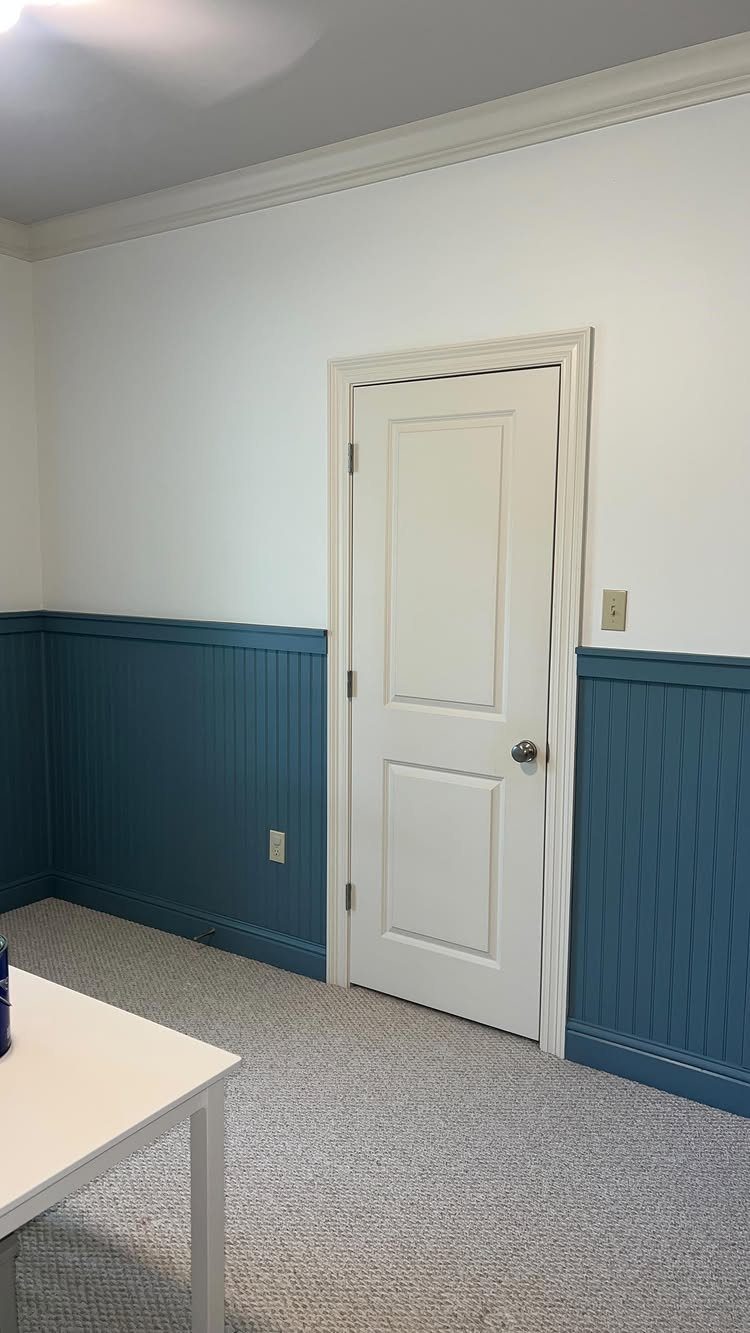 Blue beadboard wainscoting installed on the lower half of a white living room wall.