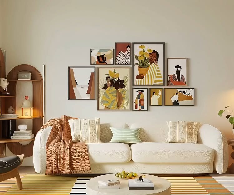 23 Wall Decor Design Ideas (Gallery Walls, Moss Walls, Rattan) 1 Framed abstract art pieces arranged in a gallery wall layout above a white sofa.