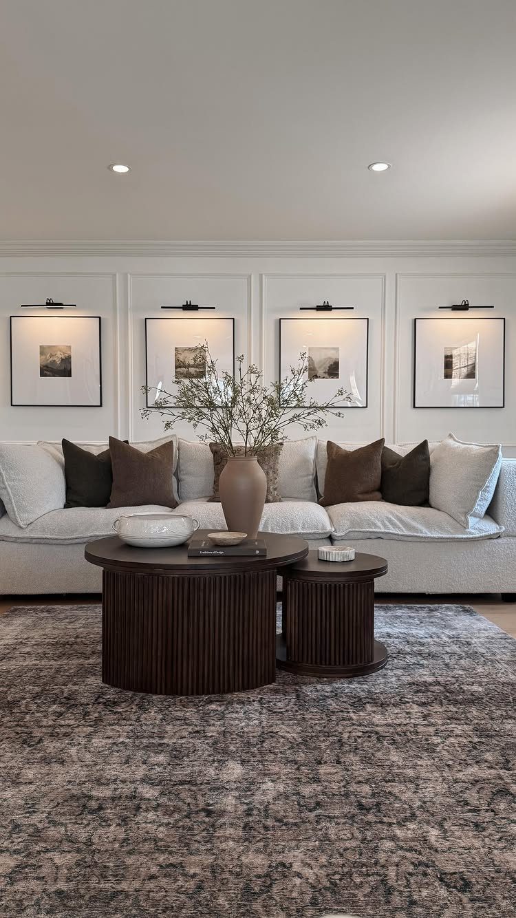 23 Wall Decor Design Ideas (Gallery Walls, Moss Walls, Rattan) 16 Four framed landscape artworks on a paneled wall, each illuminated by a black picture light.