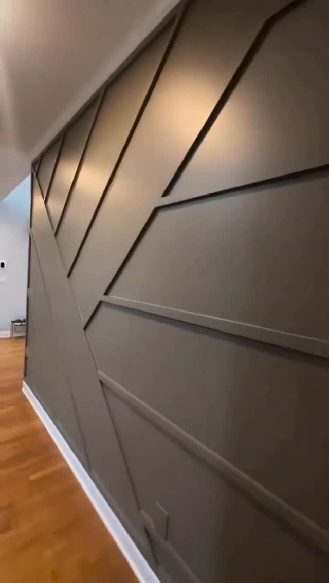 Geometric olive green wooden wall panels with raised decorative slats in a modern pattern.