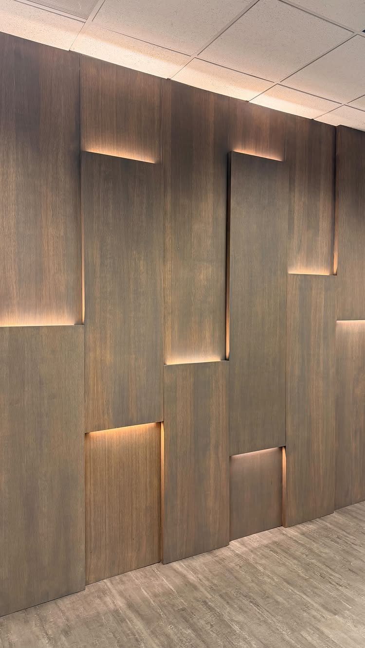 Vertical wooden wall panels with warm integrated LED backlighting in a modern interior setting.