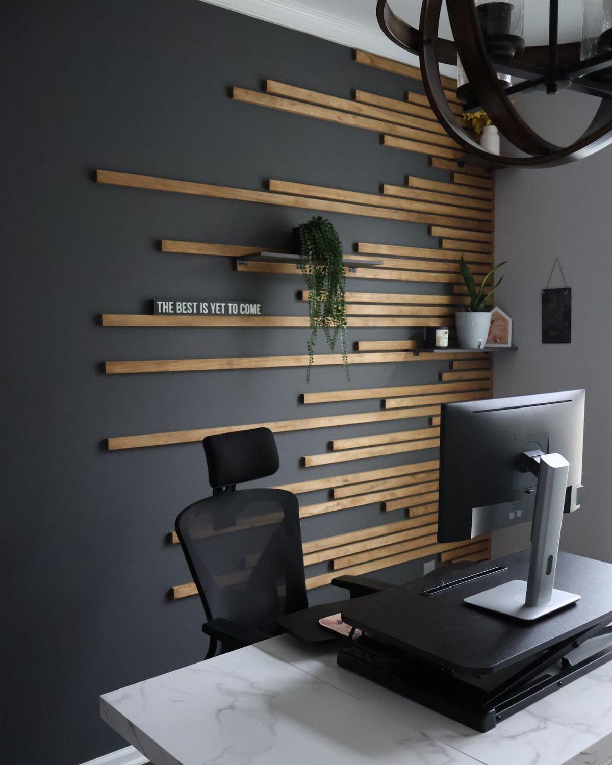 Horizontal light wood slats arranged in a staggered pattern on a dark grey accent wall.