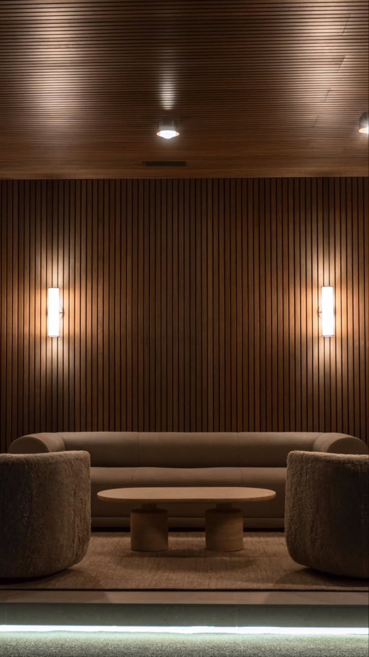Vertical wood slats cover the entire wall behind a modern living room seating area.