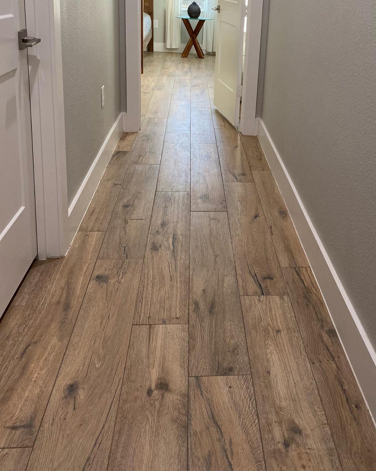 Wood Tile Pattern: 6 Layouts That Actually Work 2 Light brown wood-look floor tiles laid in a staggered pattern throughout a narrow hallway.