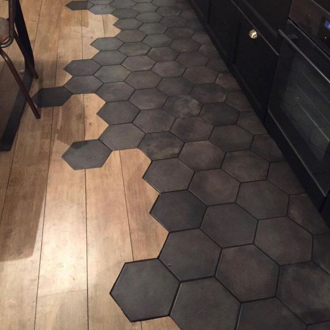 Wood Tile Pattern: 6 Layouts That Actually Work 4 Dark grey hexagonal tiles laid in a decorative pattern across a light wood floor.